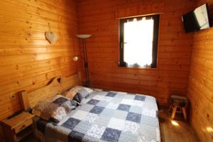 Un dormitorio con una cama en una cabaña de madera. en Maison de style chalet individuelle Le Rouge Feigne à La Bresse, en La Bresse