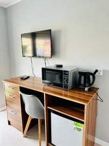 a microwave sitting on top of a wooden desk at Pokoje Gościnne in Kołobrzeg