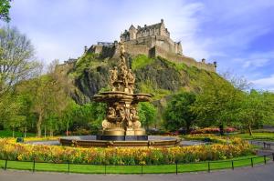 a fountain in a park with a castle on a hill at Safestay Edinburgh Cowgate in Edinburgh