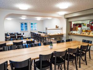 Avenches Youth Hostel في افونش: غرفة طعام كبيرة مع طاولات وكراسي