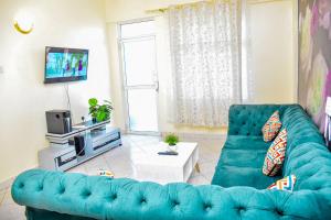 a living room with a blue couch and a tv at DESIRED 2 BEDROOM Apartment in Thika