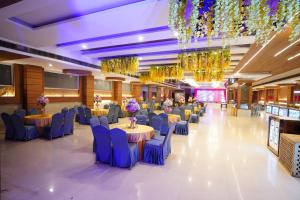 a banquet hall with blue chairs and tables and chandeliers at Hotel Classic Residency in Kālka