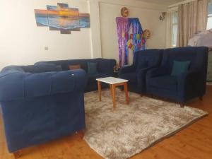 a living room with two blue couches and a table at Cozy Private Room at a Homestay with Facilities in Addis Ababa