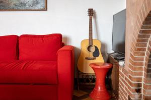 a red couch and a guitar in a living room at GuestReady - A Mediterranean chic escape in Antibes