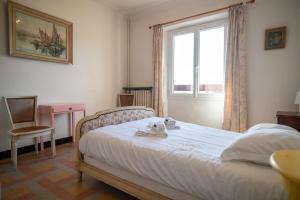 a bedroom with a bed and a window and a desk at GuestReady - A Mediterranean chic escape in Antibes