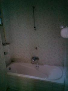 a bath tub with a faucet in a bathroom at Cozy Private Room at a Homestay with Facilities in Addis Ababa
