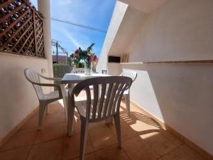 a table and chairs on the balcony of a house at Bilocale per l'affitto estivo in Torre Pali