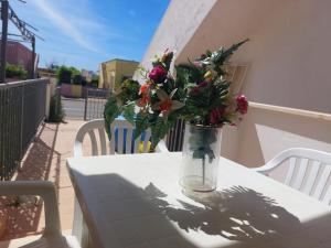 a vase of flowers on a table on a balcony at Bilocale per l'affitto estivo in Torre Pali