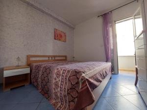 a bedroom with a bed and a window at Bilocale per l'affitto estivo in Torre Pali
