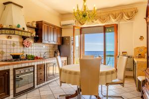eine Küche mit einem Tisch und Meerblick in der Unterkunft Acquamarina Home in Giardini-Naxos