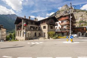 a building on the side of a street with a mountain at Cozy apartment in Courmeyeur city center in Courmayeur