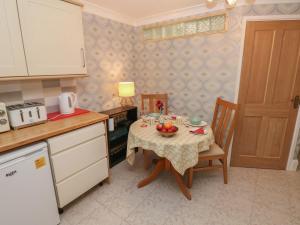 una cocina con una mesa con un bol de fruta. en The Laurels Flat en Cardiff