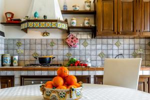 a bowl of oranges on a table in a kitchen at Acquamarina Home in Giardini Naxos