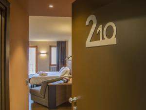 Zimmer mit einem Schlafzimmer mit einem Bett und einem Tisch in der Unterkunft Belvedere Hotel in Crodo