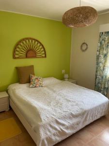 um quarto com uma cama branca e paredes verdes em VILLA 4 CHAMBRES ALTEA em Altea