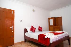 una camera da letto con un letto con cuscini rossi e bianchi di Misty Hills Munnar a Munnar