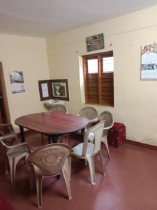 Misty Hills Munnar في مونار: غرفة طعام مع طاولة وكراسي خشبية