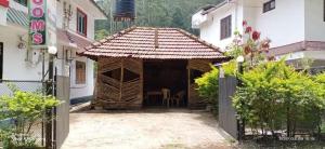 un pequeño edificio con una mesa y sillas en Misty Hills Munnar en Munnar
