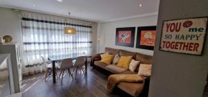 uma sala de estar com um sofá e uma mesa em Astur Playa I - WiFi · 2 Hab · 2 Baños · 4 pax em Gijón