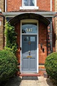 una porta blu con il numero di una casa in mattoni di Cannara B and B a Great Malvern