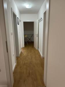 un pasillo vacío con paredes blancas y suelo de madera en Apartmani Ivana, en Prozor