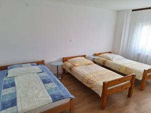 Habitación con 2 camas y mesa. en Apartmani Ivana, en Prozor