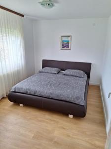 1 dormitorio con 1 cama negra en una habitación en Apartmani Ivana, en Prozor