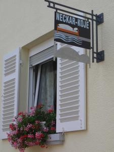 ein Fenster mit einem Schild und einem Blumenkasten in der Unterkunft Neckar-Koje in Neckarsulm
