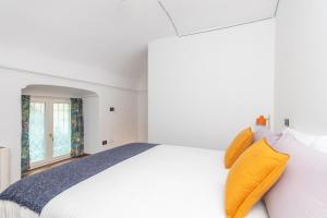 1 dormitorio blanco con 1 cama grande con almohadas amarillas en Elegant Home with Sauna in Turin by Wonderful Italy, en Turín