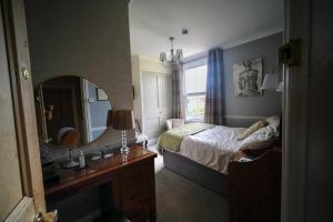 una camera con letto, specchio e lavandino di Cannara B and B a Great Malvern