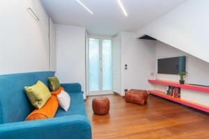 sala de estar con sofá azul y TV en Elegant Home with Sauna in Turin by Wonderful Italy, en Turín