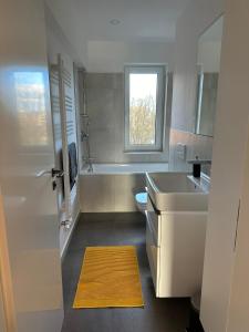 y baño con lavabo, bañera y aseo. en Modern Art Apartment Düsseldorf - 10 Min to Trade Fair & Stadium, en Düsseldorf