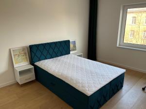 1 dormitorio con 1 cama azul en una habitación en Modern Art Apartment Düsseldorf - 10 Min to Trade Fair & Stadium, en Düsseldorf