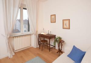 a living room with a desk and a window at Luma Apartment Navigli: Cozy and Romantic Getaway in Milan