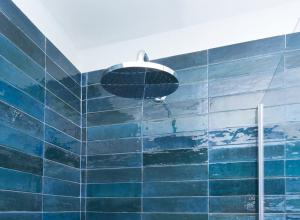 a shower on the side of a blue tiled wall at Luma Apartment Navigli: Cozy and Romantic Getaway in Milan