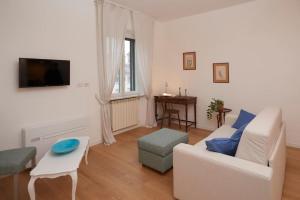 a living room with a white couch and a table at Luma Apartment Navigli: Cozy and Romantic Getaway in Milan