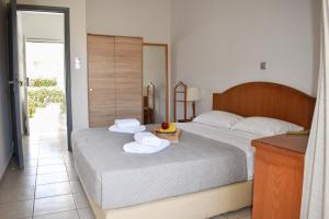 a bedroom with two beds with towels and a table at Aegean View Hotel in Sfakaki