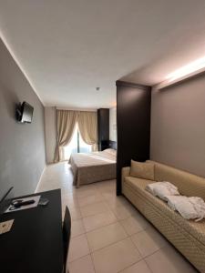 a living room with two beds and a couch at Dante Family Beach Resort in Cervia