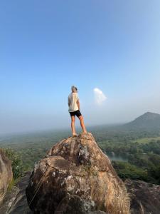 a person standing on top of a rock at Bulnewa Grammar International home stay/Tree-house 