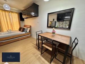 ein Wohnzimmer mit einem Esstisch und einem Bett in der Unterkunft CozyVilla at Pine Suites Tagaytay 2BR or Studio with FREE PARKING in Tagaytay
