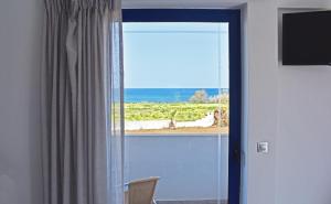 a door with a window with a view of the ocean at Aegean View Hotel in Sfakaki