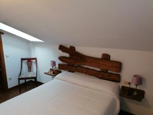 a bedroom with a large white bed and a chair at Casa rural SOROA landetxea in Arantza