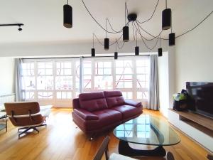 a living room with a couch and a glass table at Arq Plaza Mayor in Viveiro