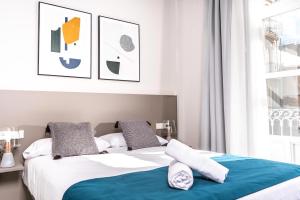 A bed or beds in a room at Apartamentos Turísticos Plaza del Rey by CartagenaSpain