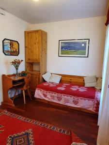 1 dormitorio con cama y escritorio. en B&B Cristallo, en Cortina dʼAmpezzo