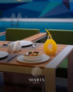 a table with a plate of food on top of it at Shaheen Hotel Baghdad in Baghdād