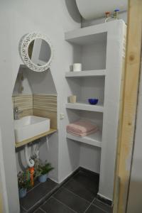 a bathroom with a sink and a mirror at DePaolis Corfu Town Apartment in Corfu Town