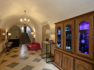 a living room with a red chair and a wine cellar at Domaine La Bonne Etoile in Beausemblant