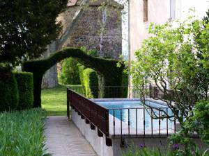 einen Pool in einem Garten neben einem Gebäude in der Unterkunft Domaine La Bonne Etoile in Beausemblant
