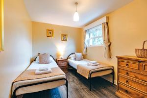 1 dormitorio con 2 camas, vestidor y ventana en Finest Retreats - Netley Hall - Jasmine, en Dorrington